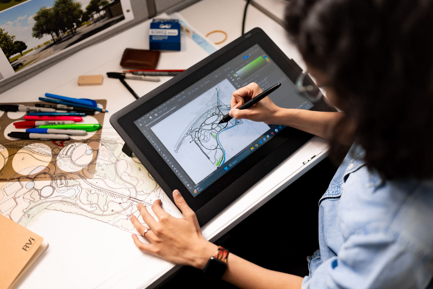 Person working on landscape design using a digital tablet at RVi Planning.
